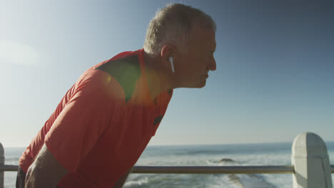 Senior-man-taking-a-break-from-running-on-the-promenade