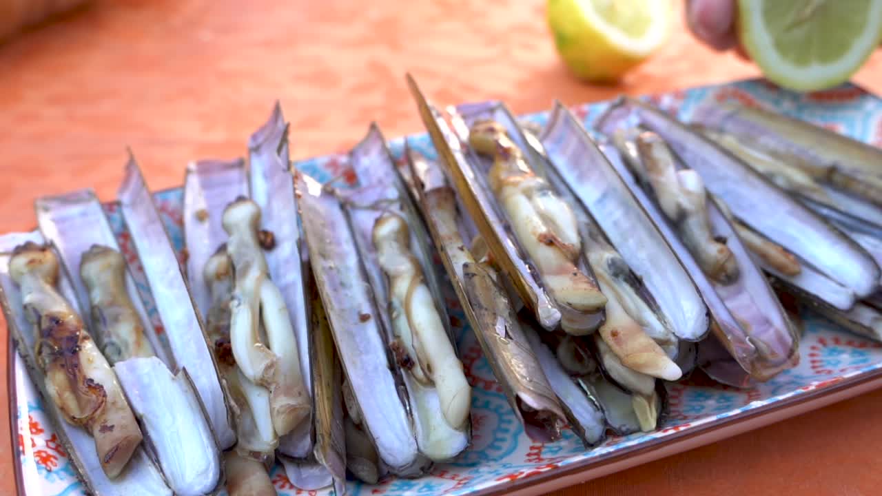 delicioso plato de navajas a la parrilla, solo pon limón y come