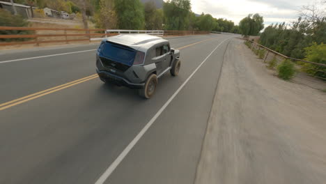 dron cinemático fpv persiguiendo a un coche de policía futurista