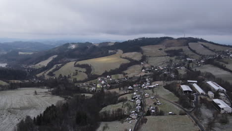 Ein-Flug-über-Die-Landschaft-Mit-Einem-Pfad,-Der-Durch-Die-Bäume-Führt,-Und-Einem-Blick-Auf-Die-Umgebung-Während-Des-Beginnenden-Schneefalls