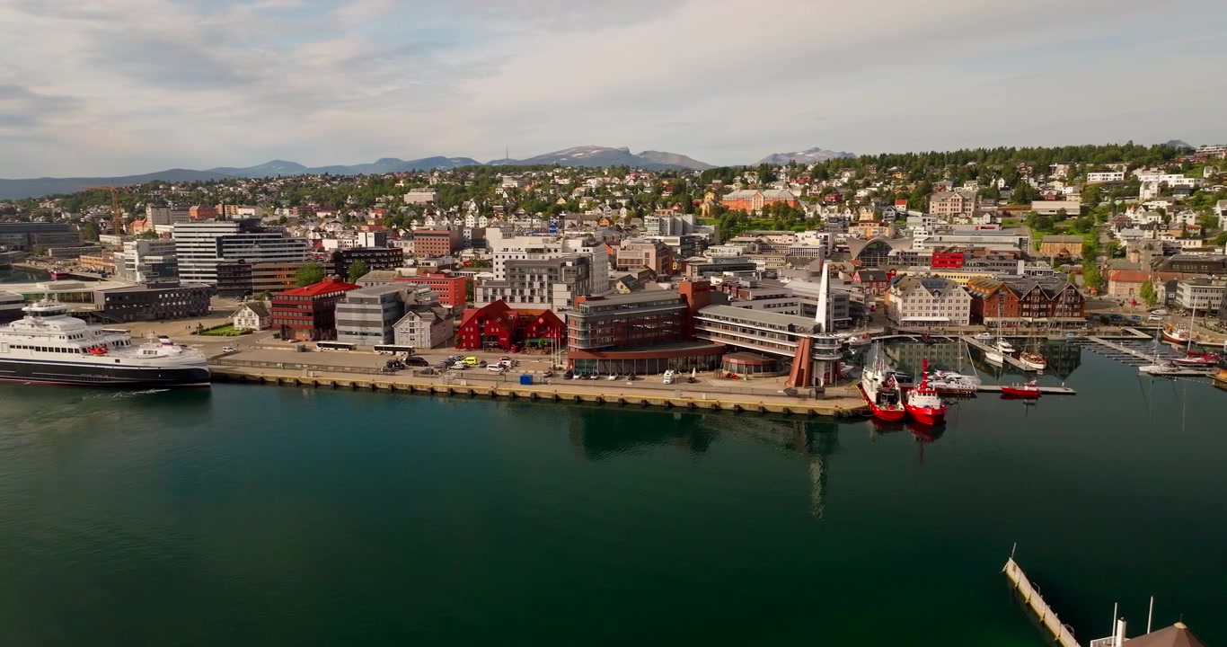 Traghetto elettrico moderno attraccato al porto nella città di Tromsø, Norvegia. Riprese aeree con drone, spazio per il testo.