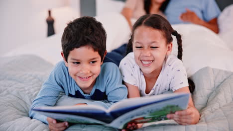 children reading a book together in bed