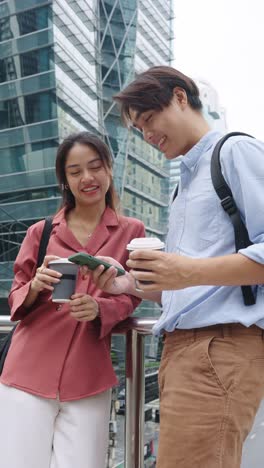 asian couple with coffee and phone in city