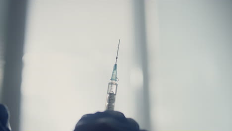 una jeringa llena de medicamentos en las manos del médico de cerca. una enfermera preparando la vacuna.
