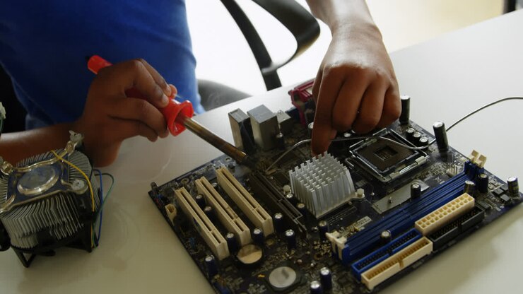 Girl soldering a circuit board at desk in office 4k