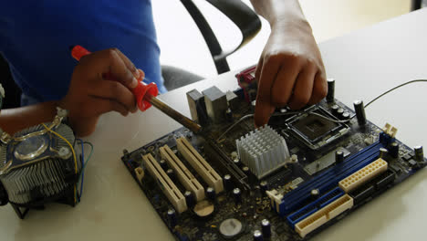 chica soldando una placa de circuito en el escritorio en la oficina 4k