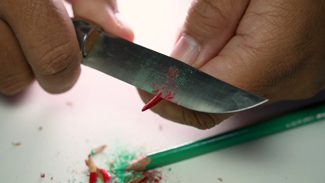 imágenes de manos afilando lentamente un lápiz y algunos lápices de colores con un cuchillo afilado