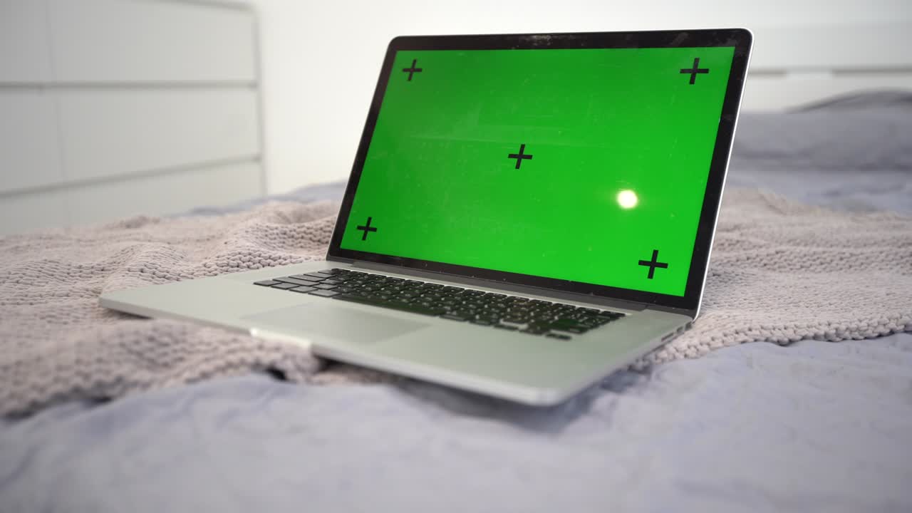 computadora portátil con pantalla verde en una cama. concepto para chats de video de aprendizaje a distancia virtual remoto.