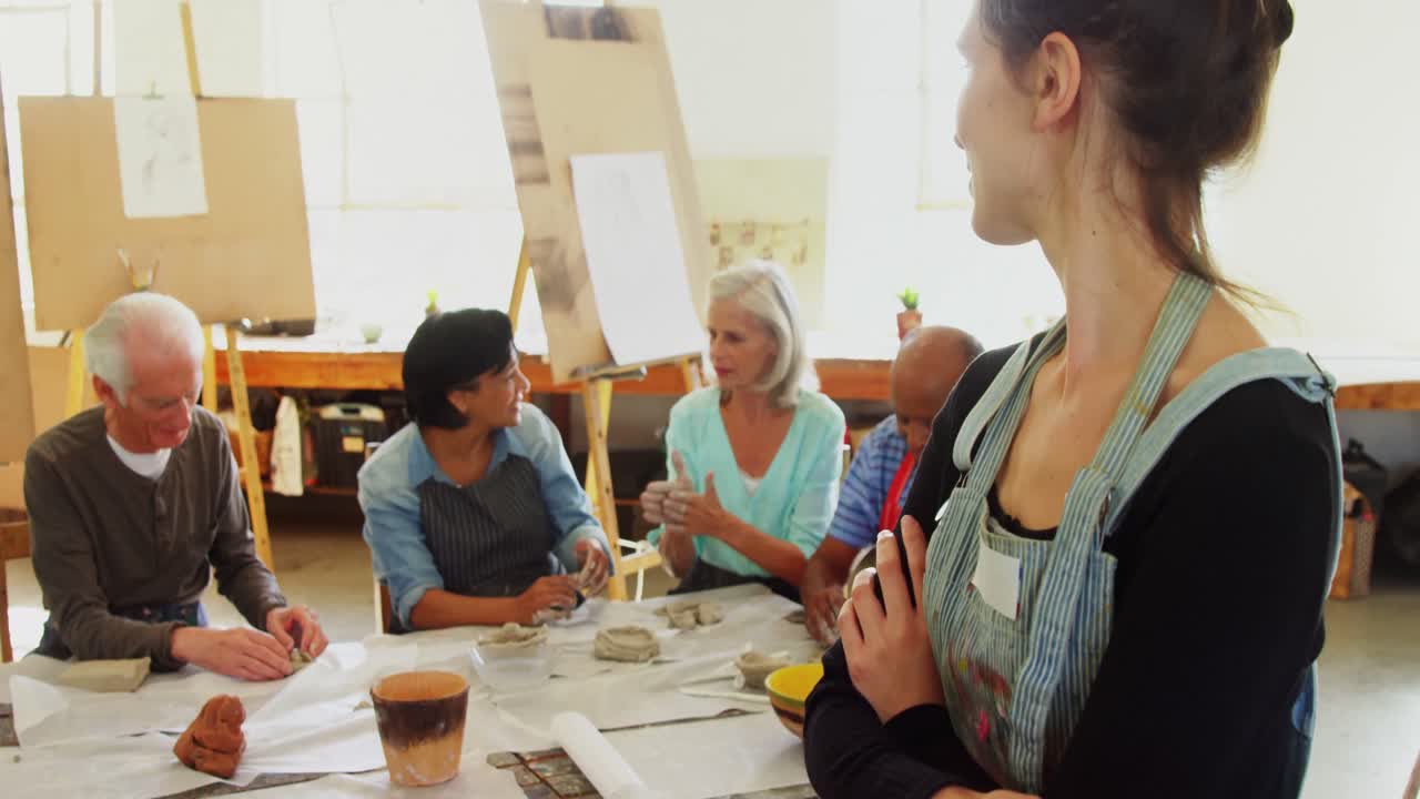 Mujer feliz de pie con los brazos cruzados en clase de dibujo 4K