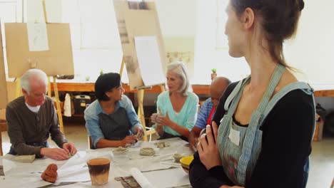 mujer feliz de pie con los brazos cruzados en la clase de dibujo 4k