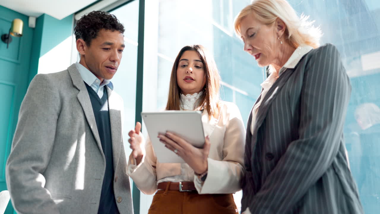 비즈니스 팀이 태블릿에서 프로젝트를 논의하고 있습니다.