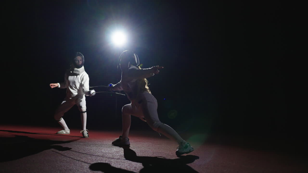 Two women fencing in a competition