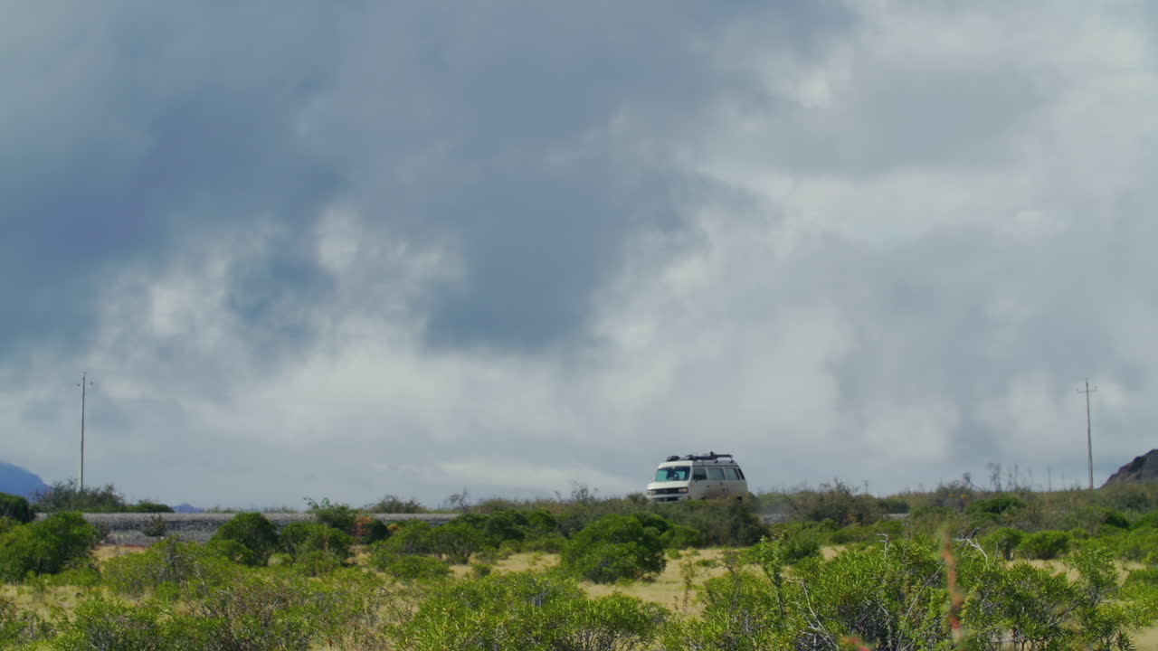 A van drives down a road through a rural area