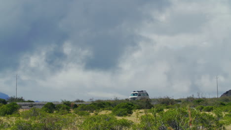 a van drives down a road through a rural area