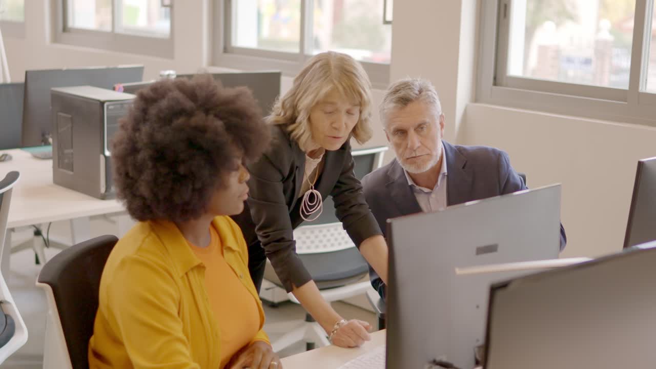 Equipe de negócios usando o computador e discutindo em um escritório de coworking