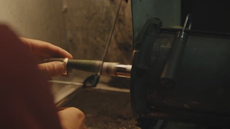 jeweler polishing a ring on a lathe