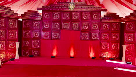 pan right shot of stage richly decorated in red for performance of indian play