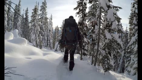 Mujer-Con-Mochila-Caminando-Por-La-Ladera-De-La-Montaña-Cubierta-De-Nieve-4k