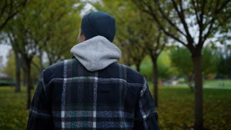 Joven-Caminando-En-El-Parque-De-Otoño