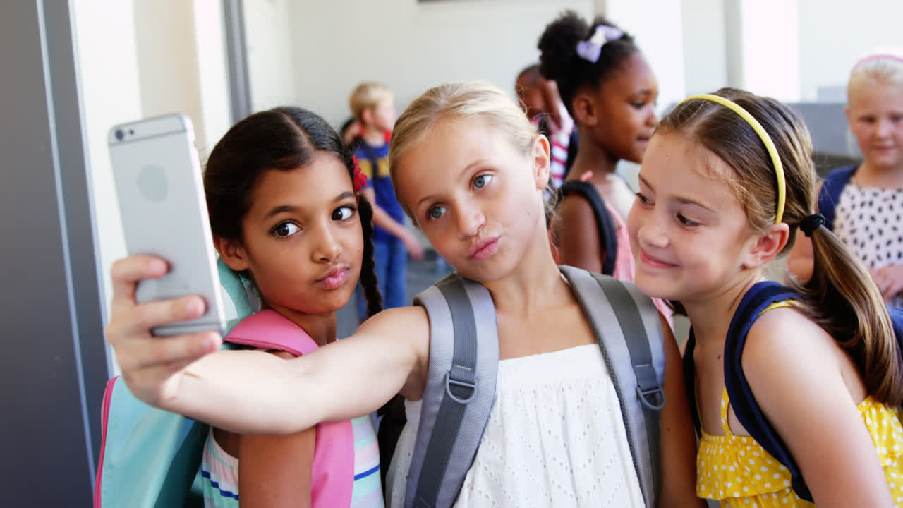 School kids taking selfie with mobile phone