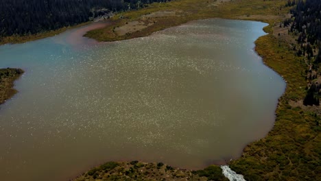 Impresionante-Paisaje-De-Drones-Aéreos-Naturaleza-Que-Se-Inclina-Hacia-Arriba-Del-Hermoso-Lago-Del-Castillo-Rojo-Inferior-Con-El-Pico-Del-Castillo-Rojo-Que-Se-Avecina-Detrás-Rodeado-De-Pinos-En-El-Bosque-Nacional-Alto-De-Uinta-En-Utah