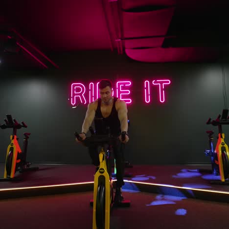 man training on spin bike. young man exercising legs doing cardio workout on cycling bike