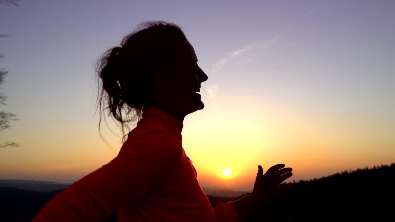 una joven atlética está corriendo al aire libre al atardecer en un paisaje montañoso.
