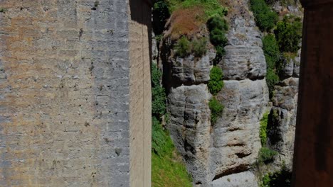 drone shot flying in under a bridge, near a wall