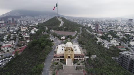 disparo de drones en un día nublado por la mañana en hasta bandera sobre el cerro obispado en la ciudad de monterrey, méxico-9