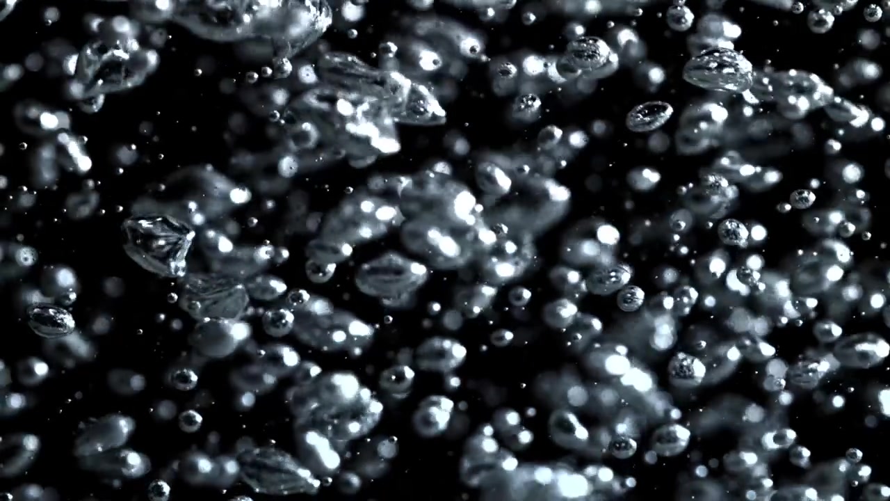 Bolle d'aria scintillanti che salgono nell'acqua su sfondo nero