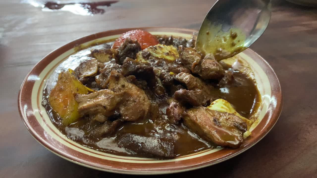 Tongseng delicious food served on a plate. Goat meat stew cooked with sweet soy sauce, coconut milk, sliced   cabbage, and tomatoes. Commonly found in Central Java, from Surakarta to Yogyakarta.