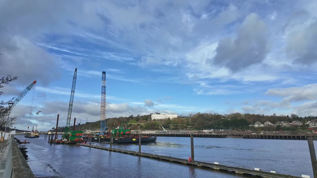 Timelapse bridge construction Waterford Quays Ireland cranes moving river flowing winter morning