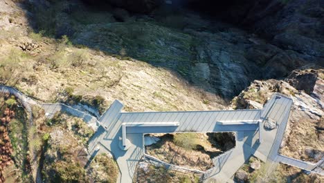 spectacular walkway above viewpoint vøringsfossen waterfall and deep canyon at hardangervidda norway - top-down aerial view of person on edge of walkway