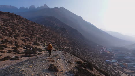 Aerial view of a tourist at a Buddhist stupa in Dingboche, Khumbu, Nepal. Mt. Ama Dablam shines in the backdrop with a panoramic 360° view of Everest region landscape during morning expedition fun