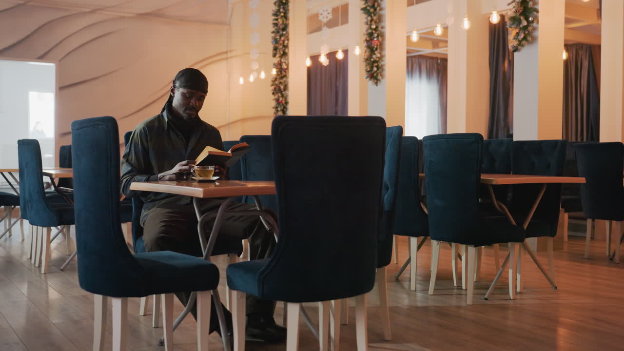 poeta silencioso inmerso en un tranquilo espacio para cenar, poeta sereno contemplando la vida en medio del cido resplandor de la tarde, un poeta introspectivo disfrutando de la soledad durante una noche tranquila en una habitacin poco iluminada