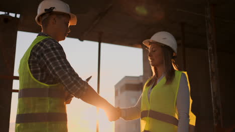 arquitecta y trabajadora de la construcción estrechando la mano. ángulo bajo de vista espacio de copia