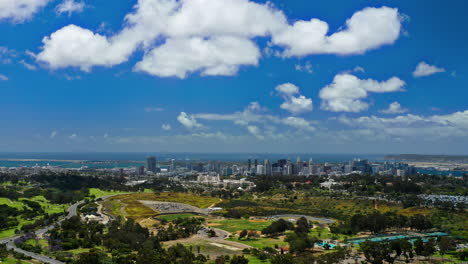 aerial timelapse of balboa park with san diego, the bay and coronado bridge in the distance.
