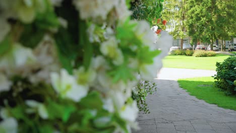 Shot-of-main-entrance-of-the-Catholic-church-of-Saint-Mary's-Scapular-decorated-with-white-flowers-and-greenery-in-Druskininkai,-Lithuania,-slow-motion