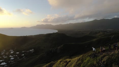 tourists overlooking a spectacular view at the lanikai pillboxes in oahu hawaii during sunset