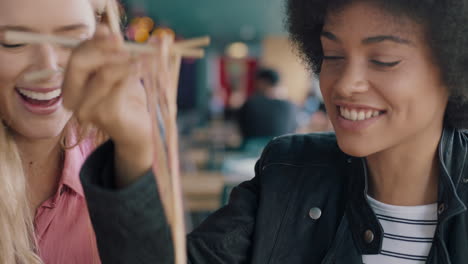 girl-friends-eating-in-restaurant-two-women-enjoying-delicious-ramen-noodles-meal-with-chopsticks-having-fun-hanging-out-together-socializing-on-weekend-4k