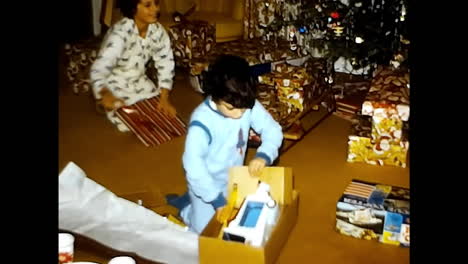 little girl playing with a box in 1970s usa. circa usa - 1970s: a young girl joyfully engages with a cardboard box, inventing her own imaginative playtime in 1970s usa.