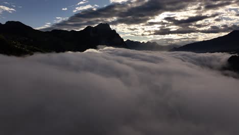 dense fog blankets valley at sunrise, dramatic sky over glarus mountains, amden, switzerland