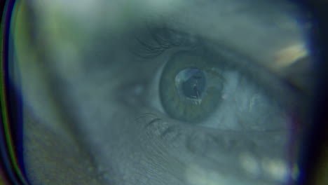 closeup of a human eye reflecting an image through glasses