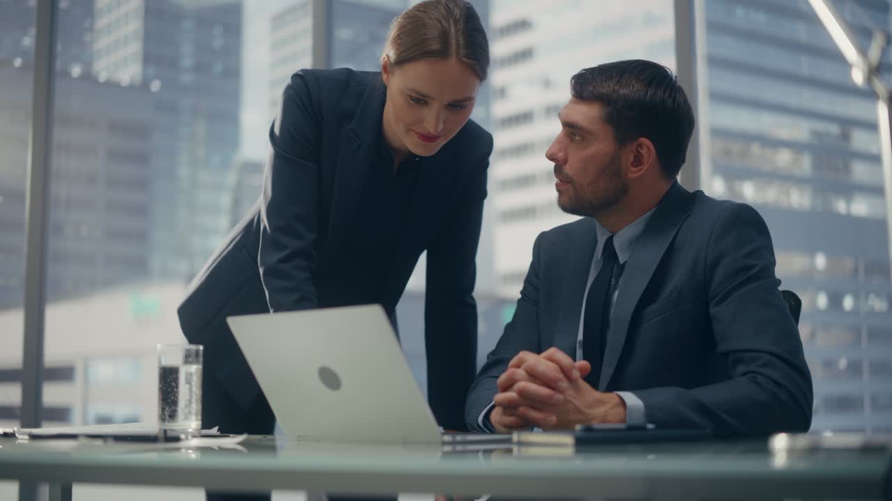 un ceo di successo e un manager di investimenti stanno parlando, usando un portatile mentre sono seduti in una sala riunioni in ufficio. due uomini d'affari di successo fanno brainstorming su un potenziale accordo di investimento fintech.