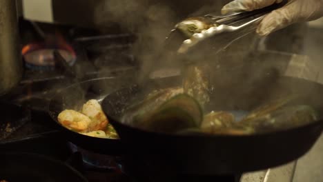 SLOWMO---New-Zealand-Greenshell-mussells,-salmon,-shrimps-cooking-in-kitchen-restaurant---CLOSE-UP