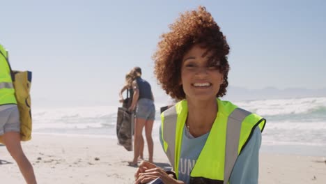 Female-volunteer-cleaning-beach-on-a-sunny-day-4k