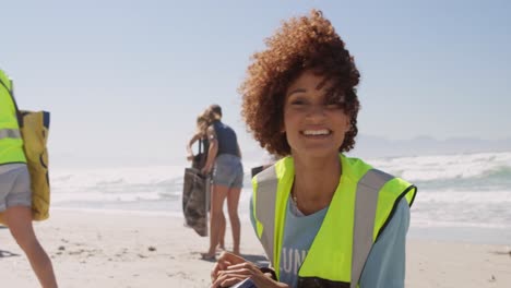 female volunteer cleaning beach on a sunny day 4k