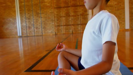 schoolboy performing yoga on a exercise mat in school 4k
