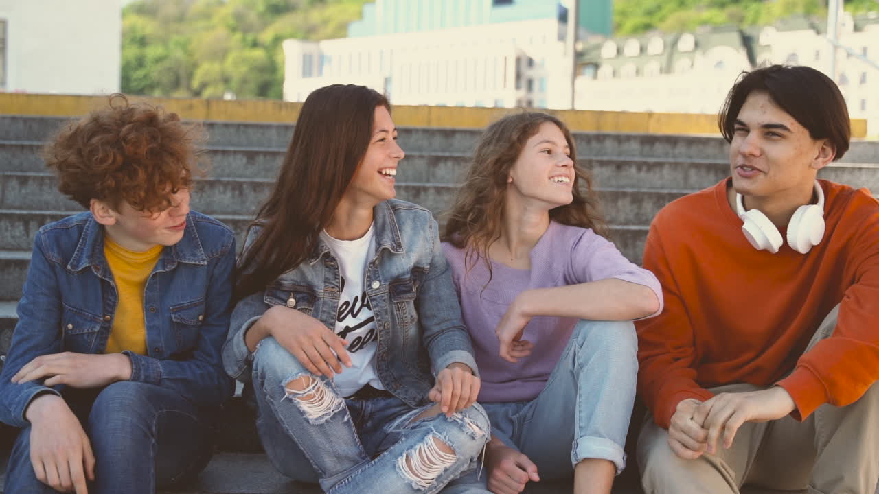un grupo de cuatro amigos adolescentes de dos chicas y dos chicos tienen una conversación divertida