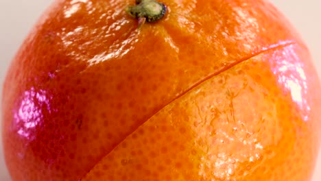 very sharp knife cutting the surface of a tangerine